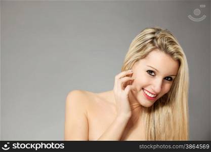 Portrait of beautiful young blonde woman over gray background