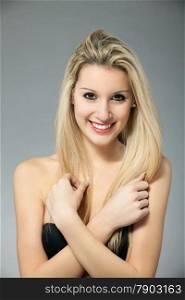 Portrait of beautiful young blonde woman over gray background
