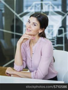 Portrait of beautiful young businesswoman at conference table