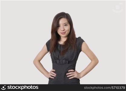 Portrait of beautiful young businesswoman with hands on hips over white background