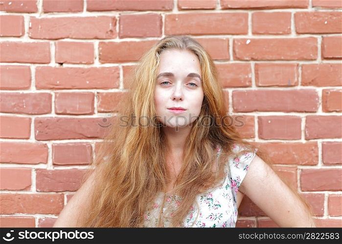 portrait of beautiful young casual girl before the brick wall