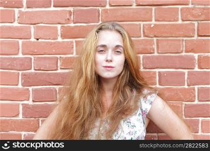 portrait of beautiful young casual girl before the brick wall