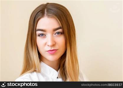 Portrait of beautiful young caucasian businesswoman looking at camera against a light yellow background. Portrait of young caucasian businesswoman
