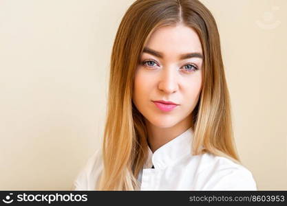 Portrait of beautiful young caucasian businesswoman looking at camera against a light yellow background. Portrait of young caucasian businesswoman