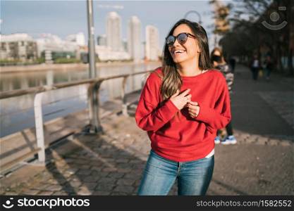 Portrait of beautiful young confident woman happy and excited outdoors in the street.