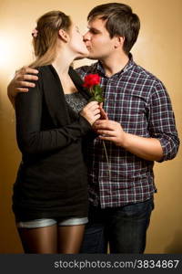 Portrait of beautiful young couple in love kissing at studio