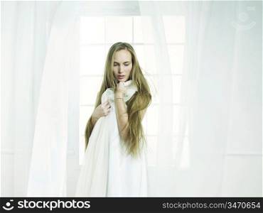 Portrait of beautiful young girl in the interior of the window