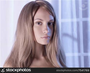 Portrait of beautiful young girl in the interior of the window