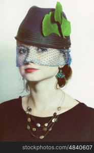 Portrait of beautiful young girl wearing hat with veil. Retro style