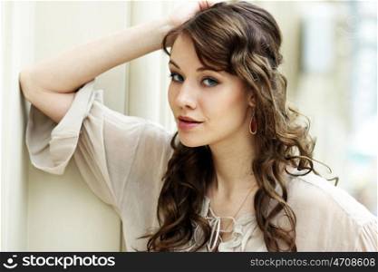 Portrait of beautiful young happy woman in disco grey dress, indoor