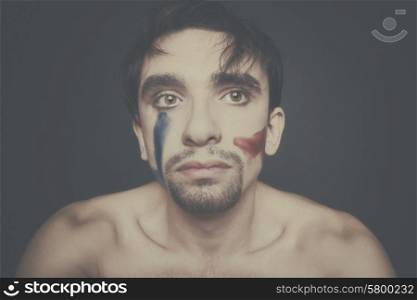 Portrait of beautiful young man with paint on his face