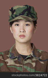 Portrait of beautiful young Marine Corps soldier in camouflage clothing over brown background