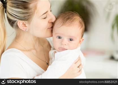 Portrait of beautiful young mother holding her baby on hands