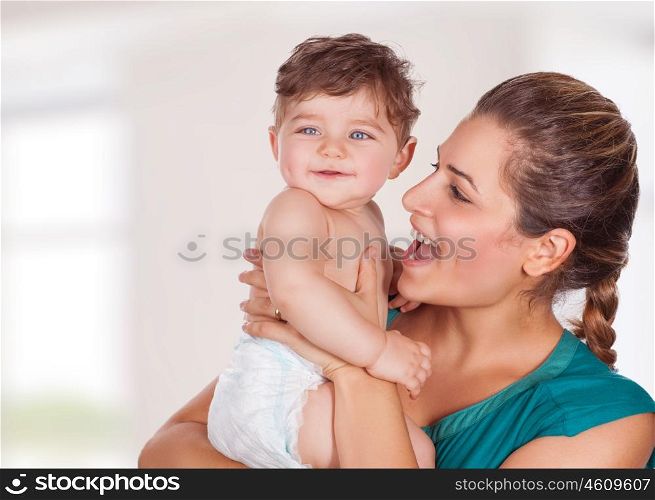 Portrait of beautiful young mother with cute adorable son having fun at home, with pleasure spending time, happy family life