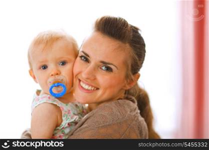 Portrait of beautiful young mother with her baby at home&#xA;