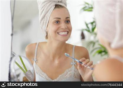 portrait of beautiful young woman brushing teeth