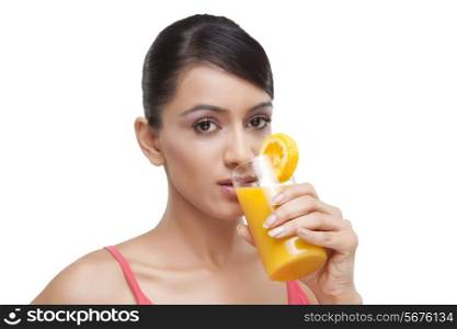 Portrait of beautiful young woman drinking orange juice