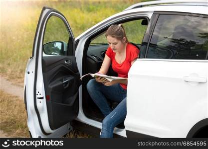 Portrait of beautiful young woman got lost while driving a car
