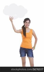 Portrait of beautiful young woman holding thought bubble over white background