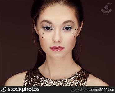 Portrait of beautiful young woman in a shiny golden dress. Brunette girl. Perfect make-up. Freckles