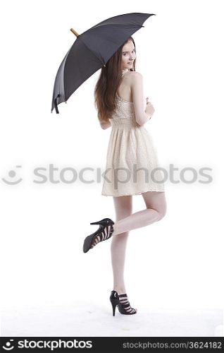 Portrait of beautiful young woman in dress with umbrella against white background