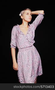 Portrait of beautiful young woman in lilac sundress on black background