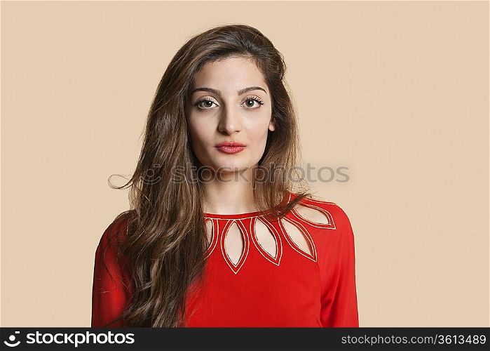Portrait of beautiful young woman in red over colored background