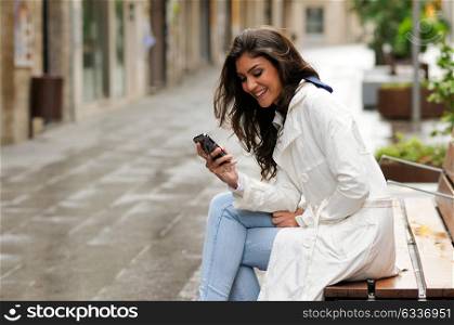 Portrait of beautiful young woman in urban background talking on phone