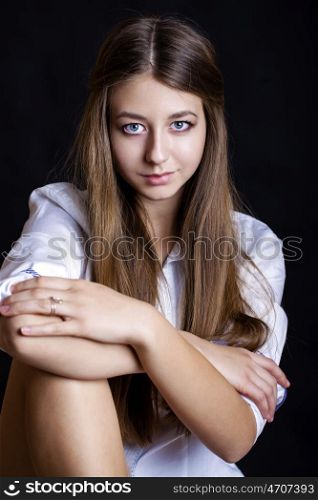 Portrait of beautiful young woman in white shirt, isolated on black background