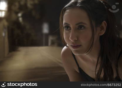 Portrait of beautiful young woman jogger on road at night