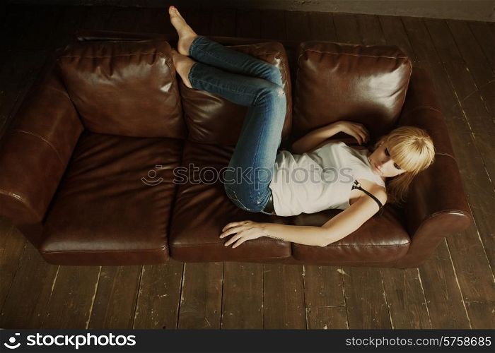 Portrait of beautiful young woman lying on sofa