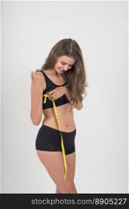 Portrait of beautiful young woman measuring her figure size with tape measure