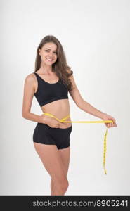 Portrait of beautiful young woman measuring her figure size with tape measure