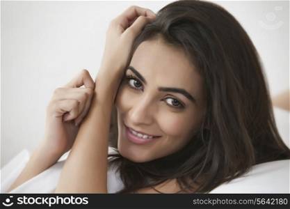 Portrait of beautiful young woman smiling in bedroom