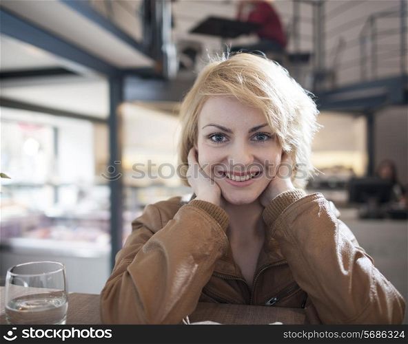 Portrait of beautiful young woman smiling in cafe