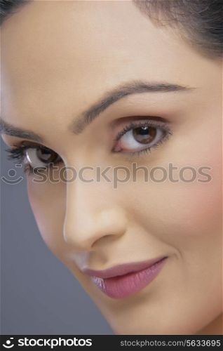 Portrait of beautiful young woman smiling over colored background