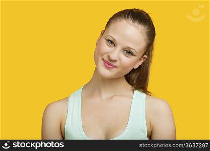 Portrait of beautiful young woman smiling over yellow background