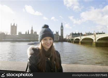 Portrait of beautiful young woman standing by river Thames; London; UK