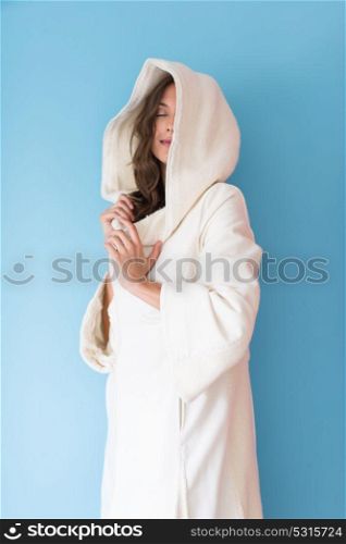 portrait of Beautiful young woman wearing a white coat with hood isolated on blue background