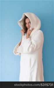 portrait of Beautiful young woman wearing a white coat with hood isolated on blue background