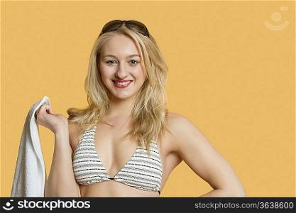 Portrait of beautiful young woman wearing bikini over colored background