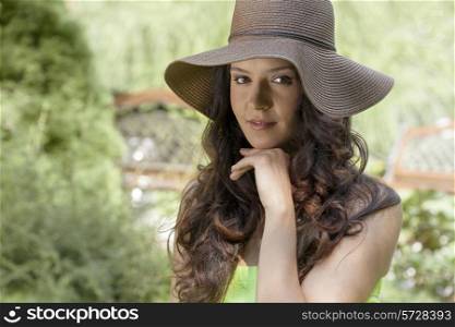 Portrait of beautiful young woman wearing sunhat in park