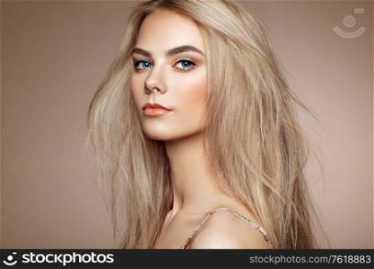 Portrait of beautiful young woman with blonde hair. Girl with long healthy and shiny smooth hair