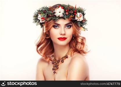 Portrait of beautiful young woman with Christmas wreath. Beautiful New Year and Christmas tree holiday hairstyle and makeup. Beauty girl portrait isolated on a white background. Colorful makeup and hair