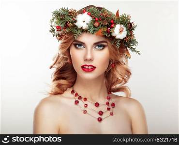 Portrait of beautiful young woman with Christmas wreath. Beautiful New Year and Christmas tree holiday hairstyle and makeup. Beauty girl portrait isolated on white background. Colorful makeup and hair