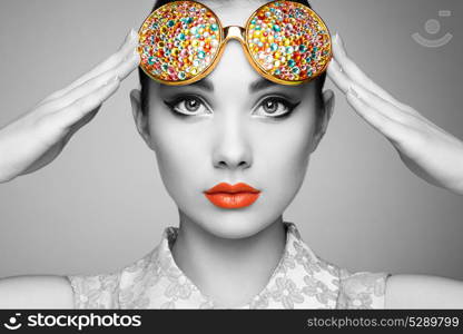 Portrait of beautiful young woman with colored glasses. Beauty fashion. Perfect make-up. Colorful decoration. Jewelry