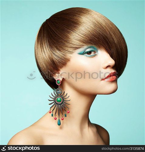 Portrait of beautiful young woman with earring. Fashion photo