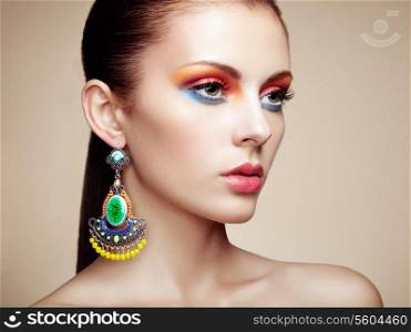 Portrait of beautiful young woman with earring. Jewelry and accessories. Perfect makeup. Fashion photo
