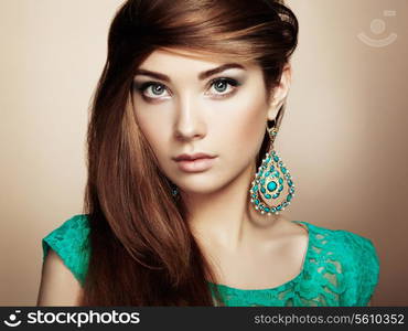 Portrait of beautiful young woman with earring. Jewelry and accessories. Perfect makeup. Fashion photo