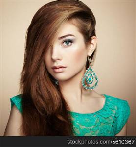 Portrait of beautiful young woman with earring. Jewelry and accessories. Perfect makeup. Fashion photo